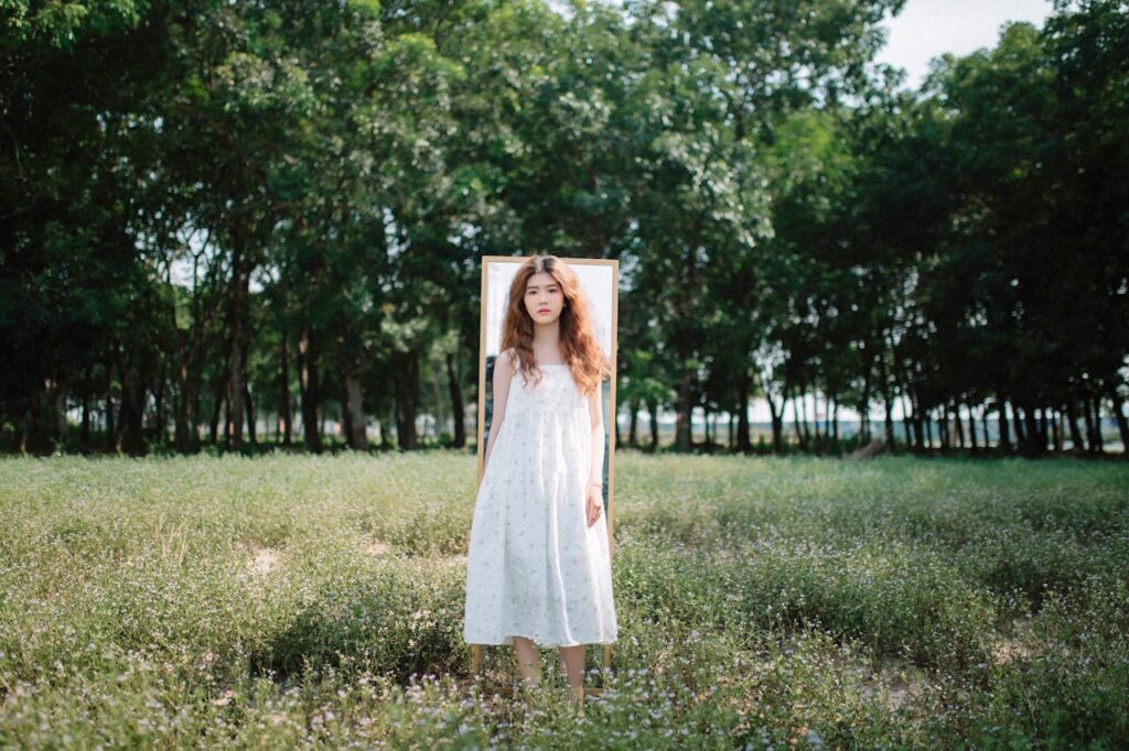 A Girl Standing in a Park with a Mirror